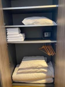 a closet with white towels and a shelf with towels at Brzece Apartman 23 in Mramor