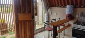 a small kitchen with a table and stools in a tiny house at Chalé Barco da areia in São Mateus