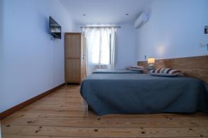 a bedroom with a bed and a wooden floor at Hospedaria Santa Maria in Beja