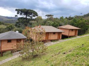 a couple of wooden buildings in a field at Cabanas Mountain in Campos do Jordão