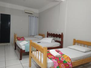 um quarto com duas camas e uma cadeira. em Hilton Hotel em Barra do Garças
