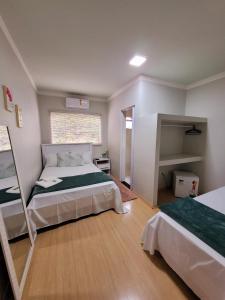 1 dormitorio con 1 cama grande y espejo en Hotel Hiperion Maringá, en Maringá