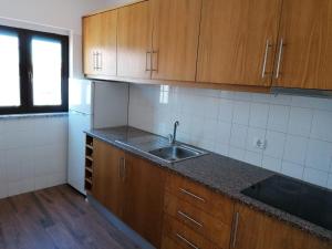 a kitchen with wooden cabinets and a sink at AAM jr in Albufeira