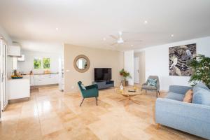 ein Wohnzimmer mit einem blauen Sofa und einem Tisch in der Unterkunft Villa Saint Corentin - 4 étoiles - Cap Est in Le François