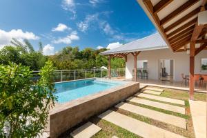 a swimming pool in the backyard of a house at Villa Saint Corentin - 4 étoiles - Cap Est in Le François