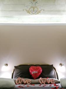 almohada de corazón sentada encima de una cama en Le Suite del Teatro cucinino privato, en Taranto