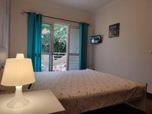 カニコにあるRefugio Madeiraのベッドルーム1室(青いカーテン、窓付)