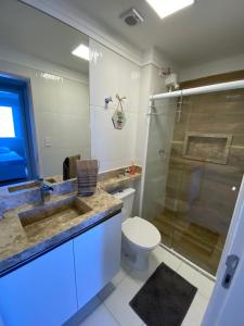 uma casa de banho com um WC, um lavatório e um chuveiro em Apto 15º andar - Varanda vista mar - Enseada no Guarujá