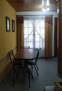 a dining room with a table and chairs and a window at Esquel te Espera in Esquel