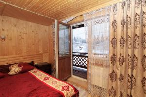a bedroom with a bed and a large window at Гостинний комплекс "У Валентини" in Yablunytsya