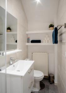 Baño blanco con aseo y lavamanos en LE NID FÉCAMPOIS - Hypercentre de Fécamp, en Fécamp