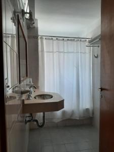 a bathroom with a sink and a shower curtain at LOWCOST MADRYN in Puerto Madryn