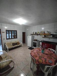 una cucina con tavolo e un letto in una camera di Casa Praia Itanhaém a Itanhaém