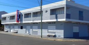 a blue and white building on the side of a street at Hotel Kruger in Tramandaí