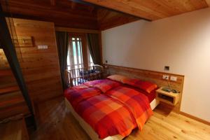 una camera con un letto in una stanza con pareti in legno di Pra de la Casa a Madonna di Campiglio