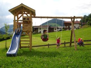 eine Gruppe von Kindern, die auf einem Spielplatz spielen in der Unterkunft Haus Gföller in Niederau