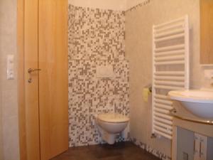 a bathroom with a toilet and a sink at Haus Gföller in Niederau