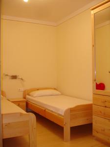 Haus Gföller في نيديراو: غرفة نوم صغيرة بسريرين وخزانة