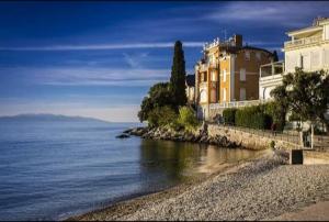 a large building on the shore of a body of water at Apartments Diella & Gabriela Opatija in Opatija