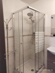 La salle de bains est pourvue d'une douche avec une porte en verre. dans l'établissement Namavistu holiday house, à Catane