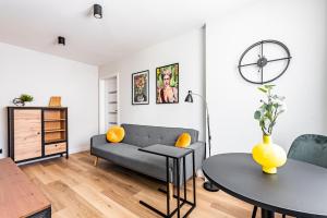 een woonkamer met een bank en een tafel bij Apartament Frida Katowice Ligota in Katowice