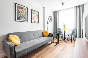 a living room with a couch and a table and chairs at Apartament Frida Katowice Ligota in Katowice