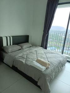łóżko w sypialni z dużym oknem w obiekcie Meritus Apartment w mieście Perai