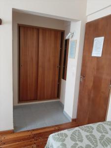 プエルト・マドリンにあるLOWCOST MADRYNのベッドルーム1室(クローゼット、木製のドア付)