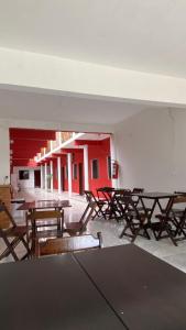 una habitación vacía con mesas y sillas de madera en Pousada Manancial en Itaúnas