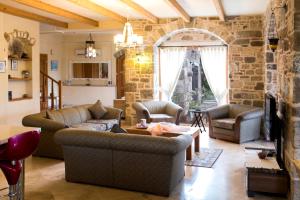 Villa Mandarin by Important Group Travel في بيتيس: غرفة معيشة بها كنبتين وجدار حجري