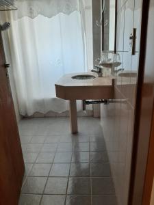 a bathroom with a sink and a mirror and a shower at LOWCOST MADRYN in Puerto Madryn