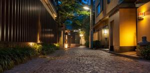 a cobblestone alley at night with a street light at G&R House 101 in Tokyo