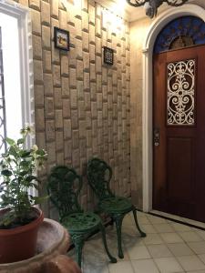 2 sillas verdes en una habitación con puerta en Casa da Josi - Pajuçara en Maceió