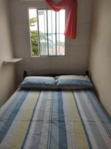 a bed in a room with a window at Flats e suites El Shaday in Porto De Galinhas