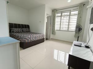 ein Wohnzimmer mit einem Bett und einem Fenster in der Unterkunft PD Batu 9 Cocobay apartment with family in Kampong Tanah Merah