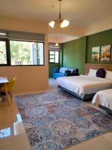 a bedroom with two beds and a rug at 910 Hostel 城南館-自助入住 in Yuli