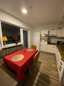 a kitchen with a table with a red table cloth at Stern Unterkunft bis zu 9 Betten verfügbar in Bremen