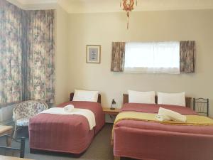 ダニーデンにあるDunedin Classic Stayのベッドが2つと窓のある部屋 +10枚の写真