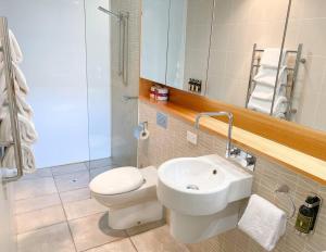 a bathroom with a white toilet and a sink at Luxury Hobart Waterfront Apartment with views! in Hobart