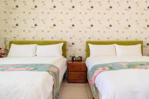 twee bedden naast elkaar in een kamer bij Ying Hsuan House in Hualien