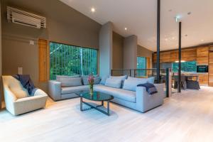 a living room with two couches and a table at Boheme by H2 Life in Kutchan