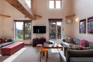 a living room with couches and a tv at Gondola Chalet by H2 Life in Niseko