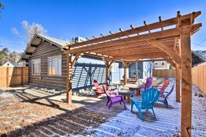 a patio with colorful chairs and a wooden pergola at Downtown Buena Vista Cabin with Patio and Grill! in Buena Vista