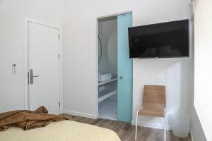 1 dormitorio con puerta azul y TV en la pared en Colina Inn, en Escazú