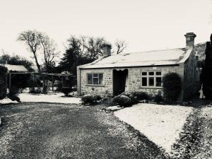 Historic Clyde cottage guest house في كلايد: صورة بيضاء وسوداء لبيت حجري