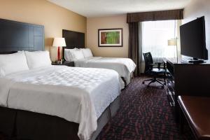 a hotel room with two beds and a television at Holiday Inn Wichita East I-35, an IHG Hotel in Wichita