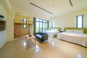 a hotel room with two beds and a chair at 太魯閣豐生活海館包棟民宿 T-aroko Fengst-ay Ocean Villa-------根據訂房人數提供相對的房間數量 Provide different number of rooms according to the number of people in the reservation in Shunan +29 photos