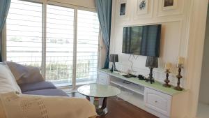 - un salon avec un canapé, une télévision et une table dans l'établissement Lake Residence No73 - Classic Style, Cozy & Best Photography, à Puchong