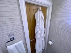 a towel hanging on the door of a bathroom at Station Rooms in Winchester