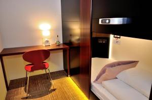 a room with a couch, chair and a lamp at Spa&Capsule Hotel Grandpark Inn Kitasenju in Tokyo